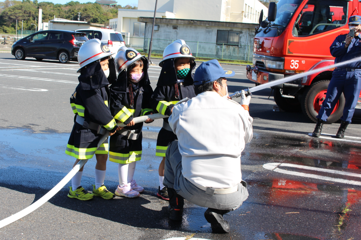 防火服を着て、放水訓練を体験する4才児
