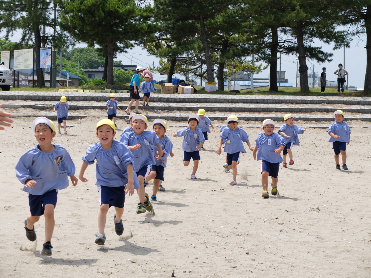 砂浜を楽しそうに走る5才児の様子