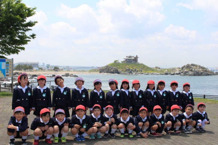 蕪島をバックに撮影した5才児クラスの集合写真